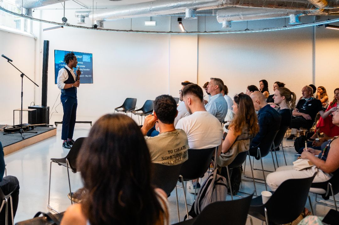 Steven Dossou speaking to a seated audience at a startup event