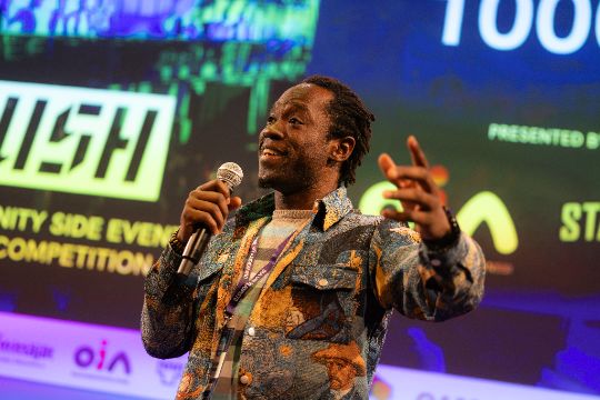 Steven Dossou speaking on stage
