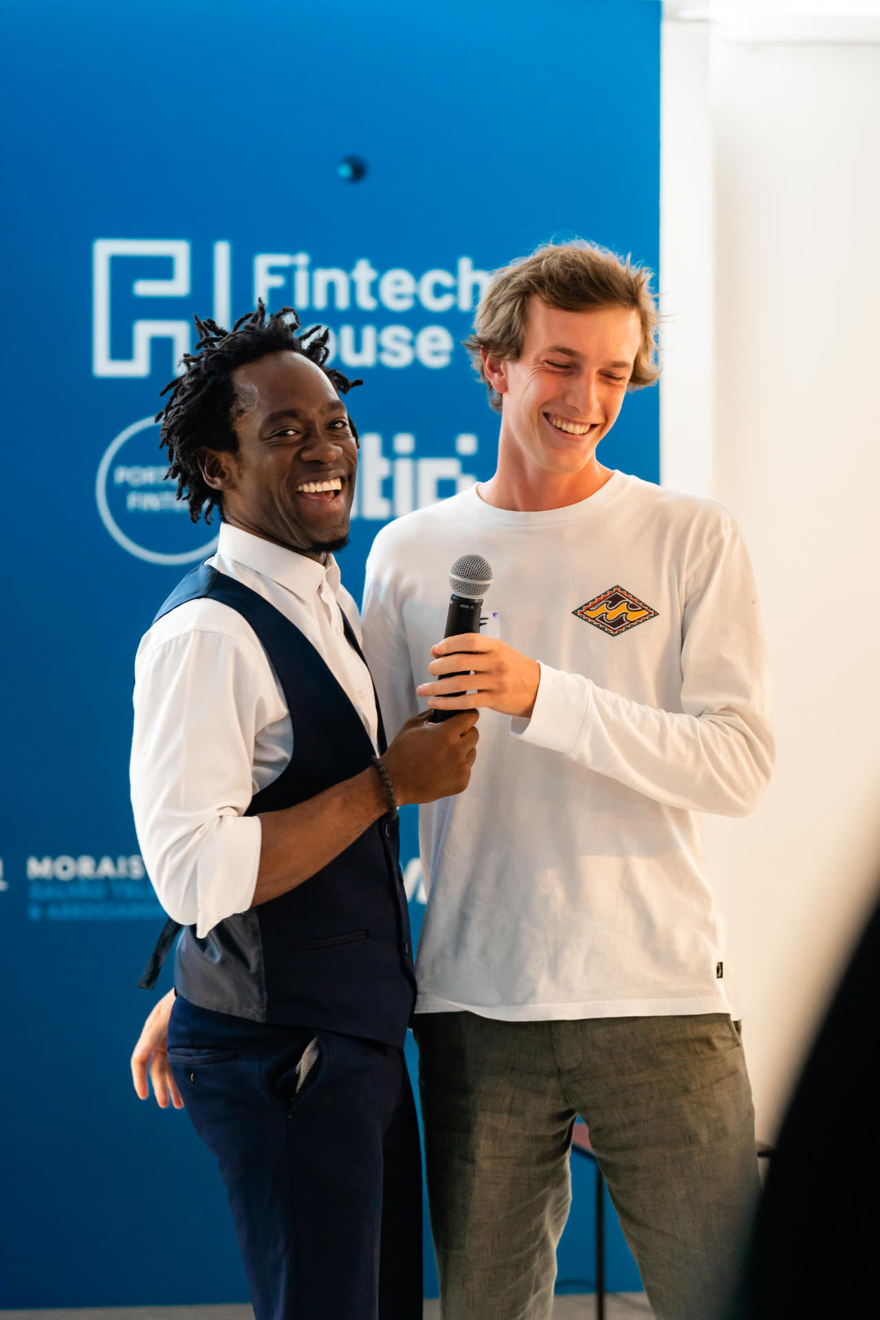 Steven Dossou laughing with a participant after a talk